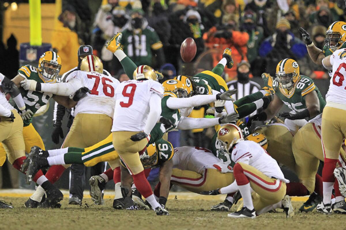 San Francisco kicker Phil Dawson kicks the winning field goal through the arms of Green Bay Packers cornerback Davon House during the 49ers' 23-20 NFC wild-card playoff win Sunday.