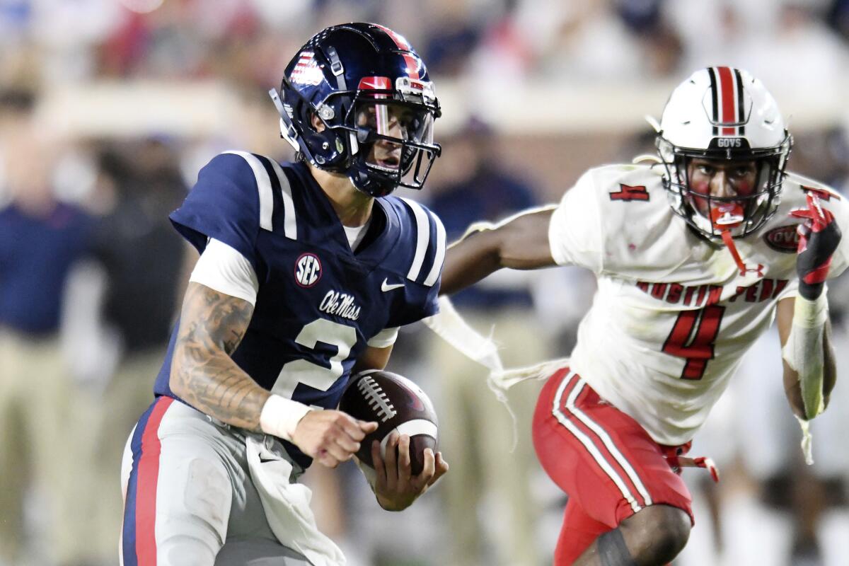 Mississippi quarterback Matt Corral (2) is chased by Austin Peay cornerback Koby Perry (4) during an NCAA college football game in Oxford, Miss., Saturday, Sept. 11, 2021. (AP Photo/Bruce Newman)