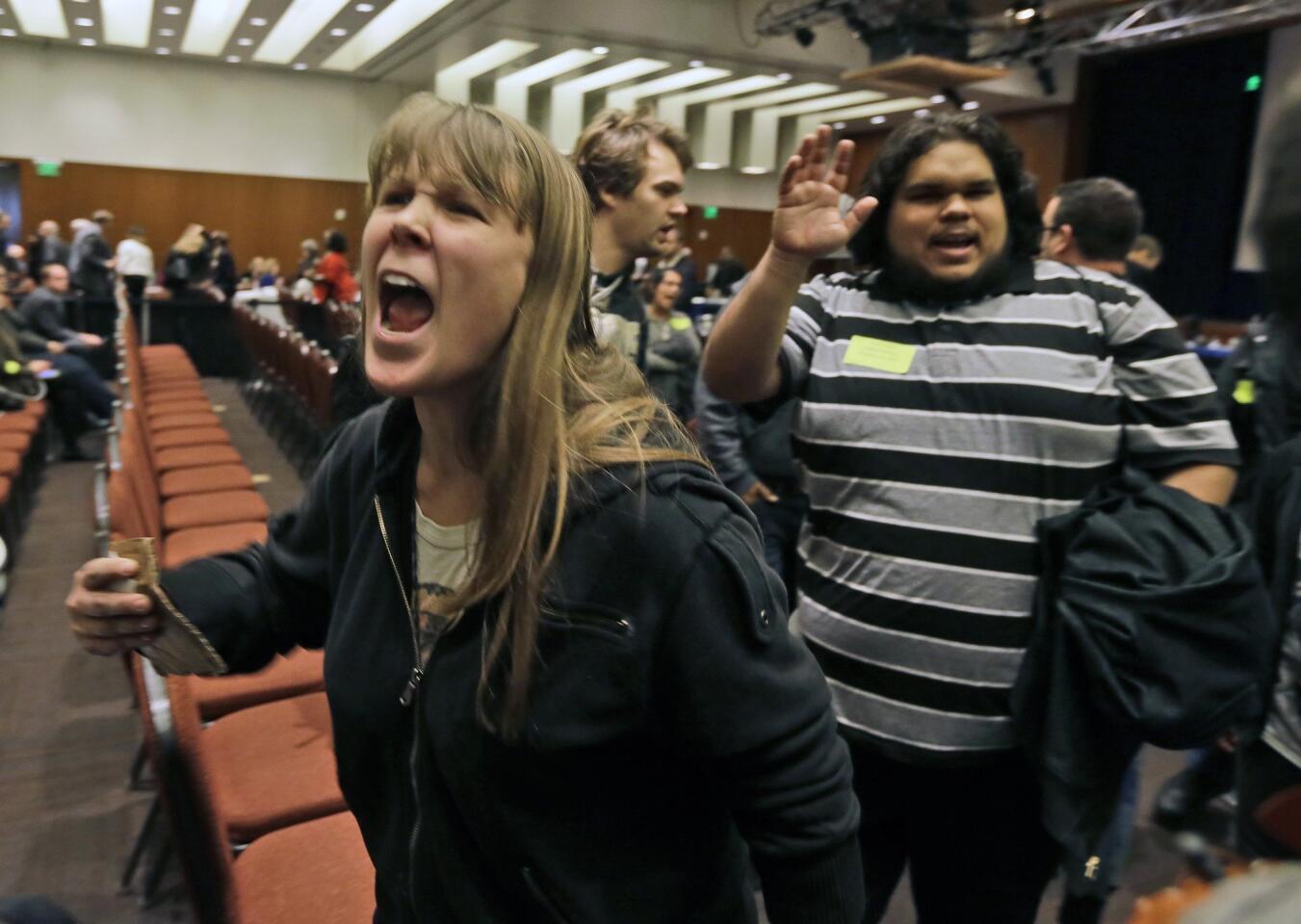 Amelia Itayre, 23, and Sebastian Cano, 21, students at UC Davis, react after the vote to raise tuition fees was announced during the UC regents meeting in San Francisco on Thursday.