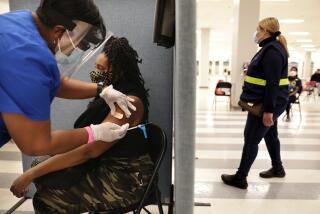 LOS ANGELES-CA-MARCH 11, 2021: A'ja Thrasher, 37, of View Park, gets a one-dose Janssen COVID-19 vaccine by Johnson & Johnson, by nurse LeShay Brown, left, following a media event hosted by The California Department of Public Health as part of the states efforts to increase vaccine acceptance among groups that are less likely to be vaccinated, and highlights California's efforts to equitably and efficiently administer COVID vaccines, at the Baldwin Hills Crenshaw Plaza in Los Angeles on Thursday, March 11, 2021. (Christina House / Los Angeles Times)