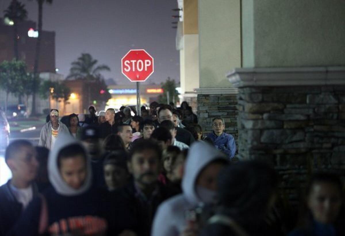 Customers line up outside a Toys R Us for Black Friday deals.
