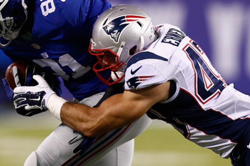 New England's Nate Ebner, right, tries to bring down Adrien Robinson of the New York Giants on Aug. 28, 2014.