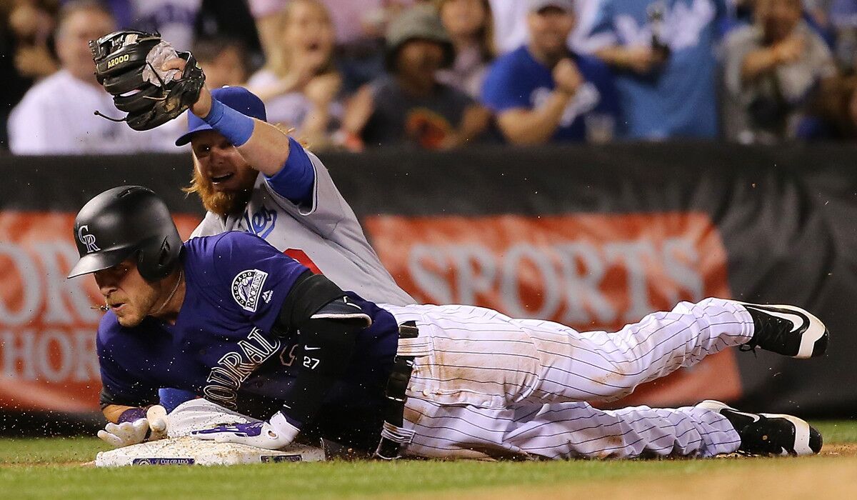 Dodgers third baseman Justin Turner tags out Colorado Rockies' Trevor Story as he attempts to triple in the fifth inning on Friday.