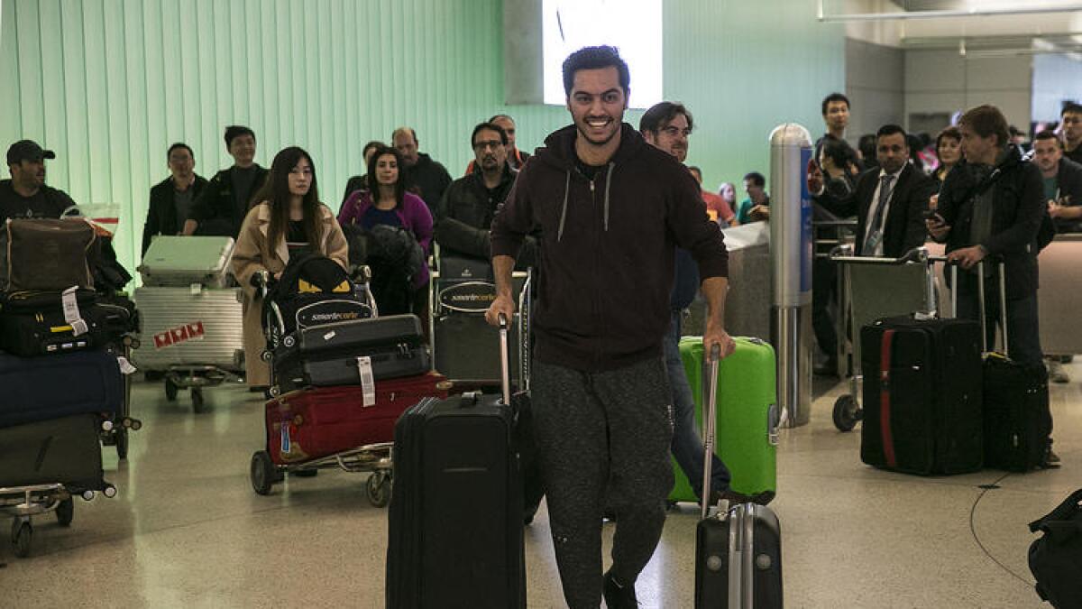 Abdullah Al-Rifaie rushes to meet his family at Los Angeles International Airport on Sunday after waiting for several days in Jordan to see if he would be allowed to reenter the U.S.