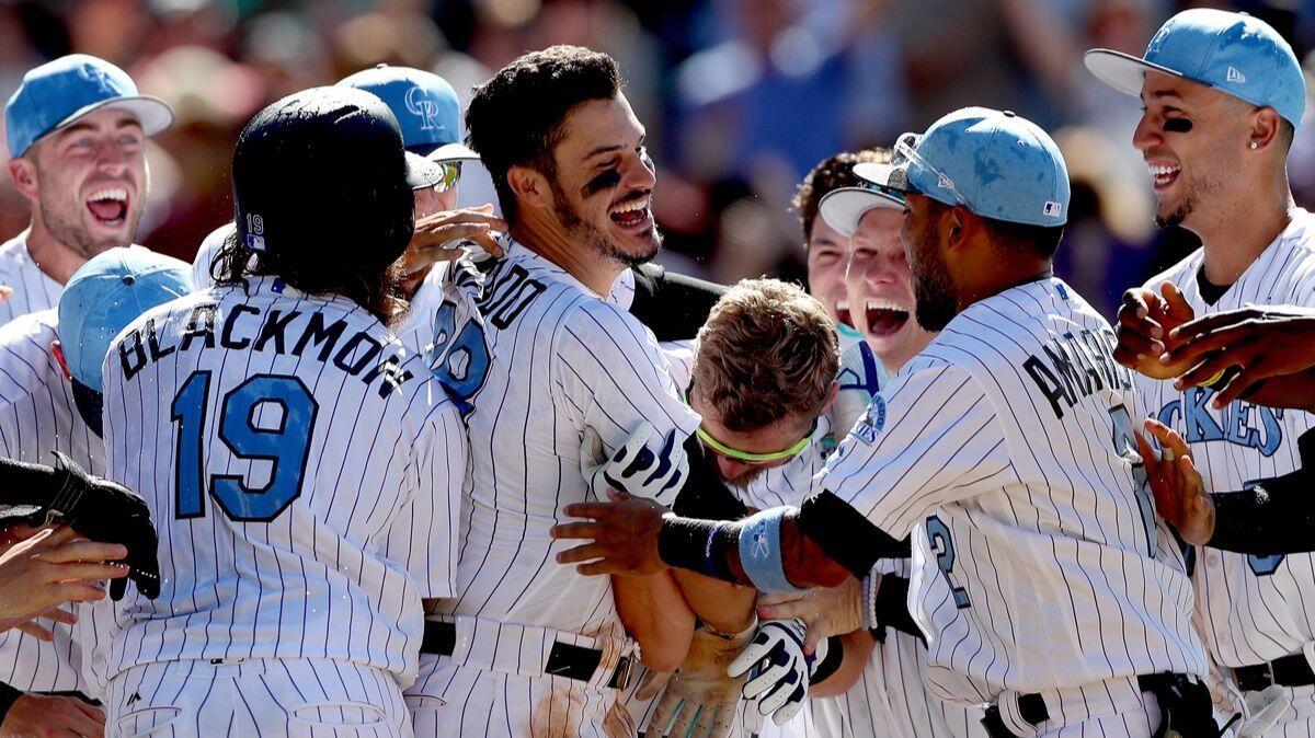 Colorado Rockies third baseman Nolan Arenado (28) celebrates with teammates after hitting a walk-off home run in the ninth inning against the San Francisco Giants on Sunday.