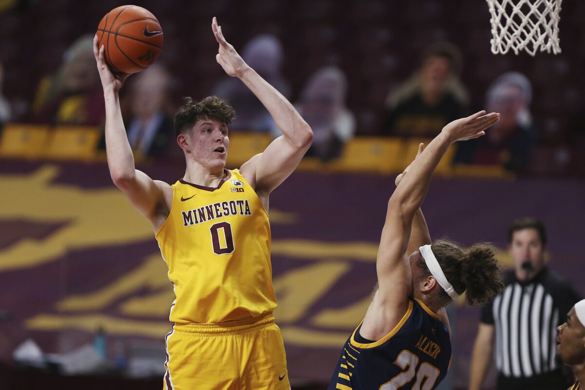 Minnesota center Liam Robbins (0) shoots over UMKC forward Josiah Allick (20) during the first half of an NCAA college basketball game Thursday, Dec. 10, 2020, in Minneapolis. (AP Photo/Stacy Bengs)