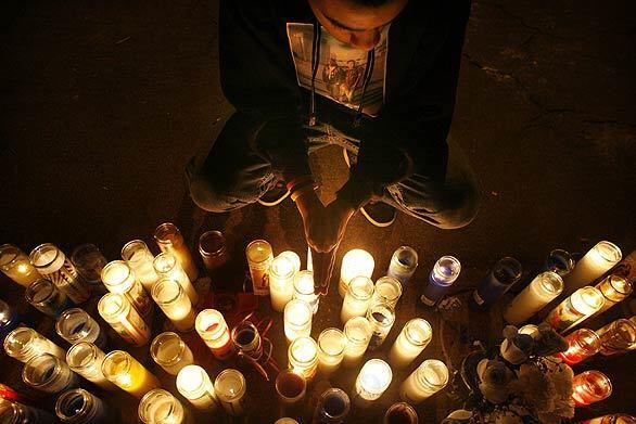Marc, 15, relights candles at a vigil marking the spot where his friend, Jamiel "Jazz" Shaw Jr., was shot to death. The 17-year-old, who was not a gang member, was only three doors from his home when two men in a car pulled up next to him, asked if he belonged to a gang, and then shot him when he apparently didn't answer, authorities say.