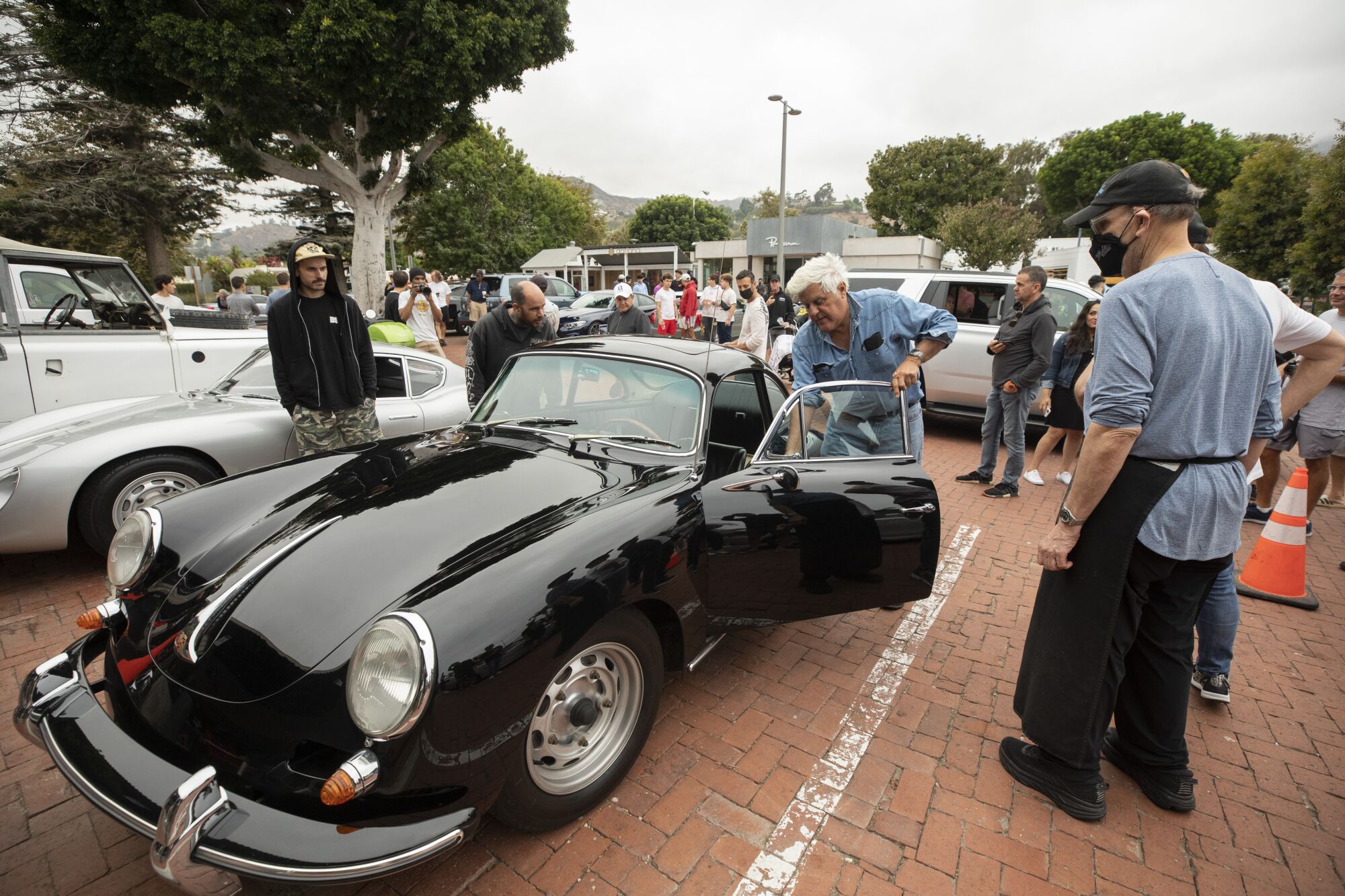 Bill Miller, right, the owner of Malibu Kitchen, greets Jay Leno, who pulled up in his 1963 Porsche Carrera 2.