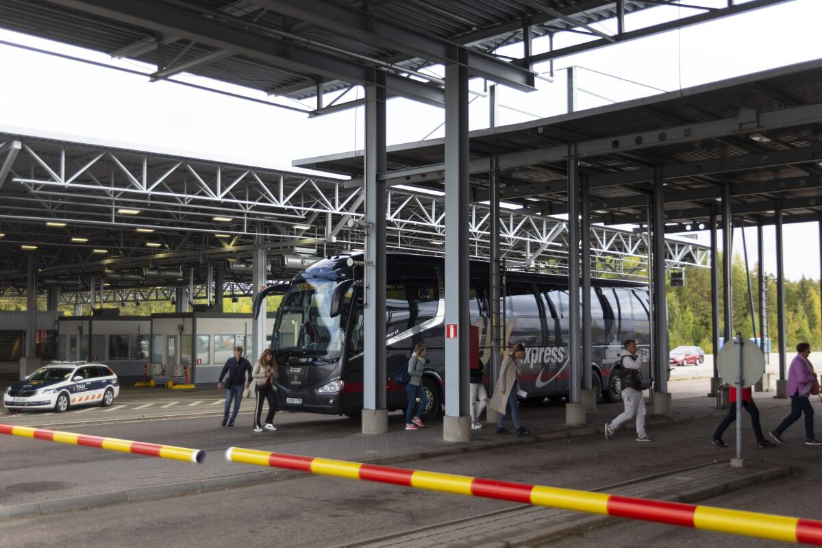 Russian passengers exit a bus at a border check point between Finland and Russia.