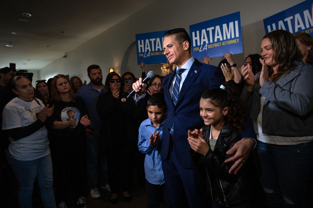 A man and his family stand in a crowd at a campaign event.