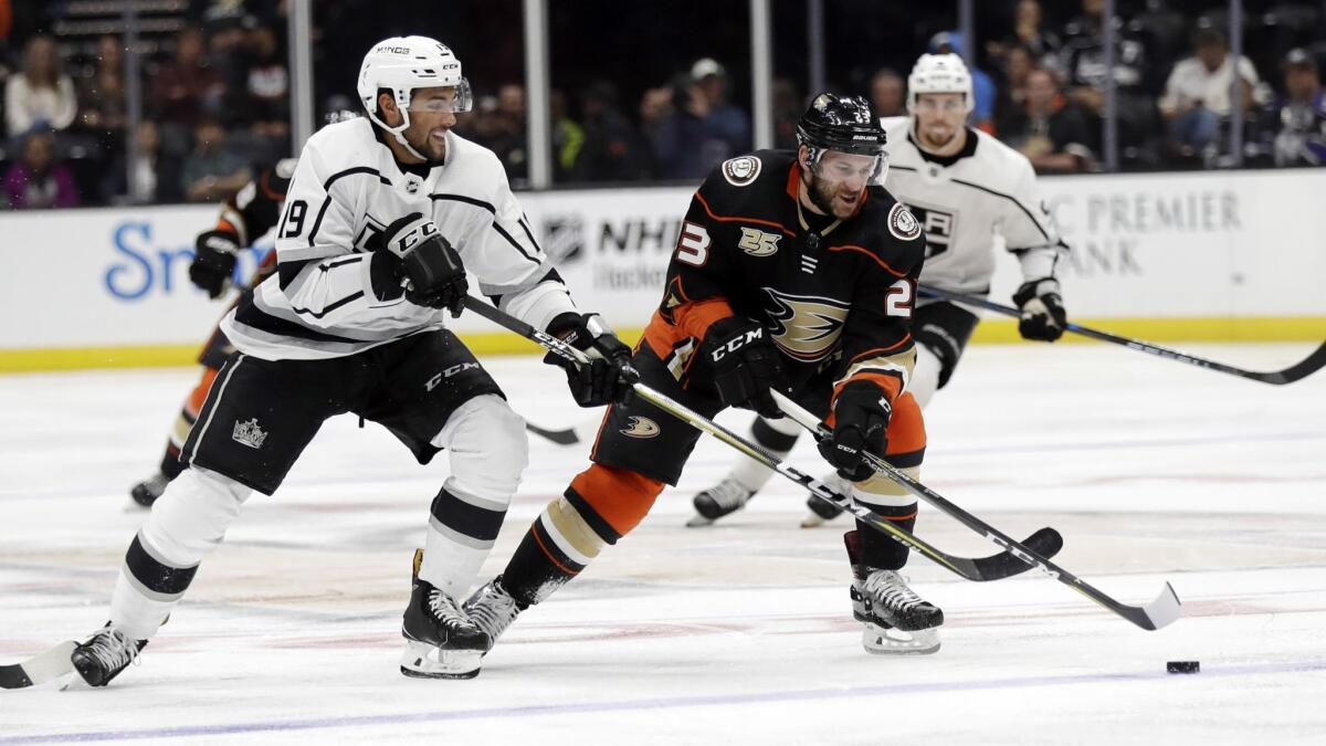 Ducks' Brian Gibbons (23), center, is defended by Kings' Alex Iafallo during the second period of a preseason game on Wednesday in Anaheim.
