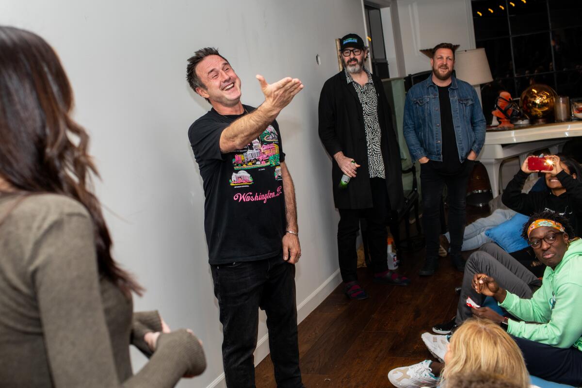 David Arquette gestures to the crowd as his wife Christina McLarty Arquette, Price James, David Darg look on.
