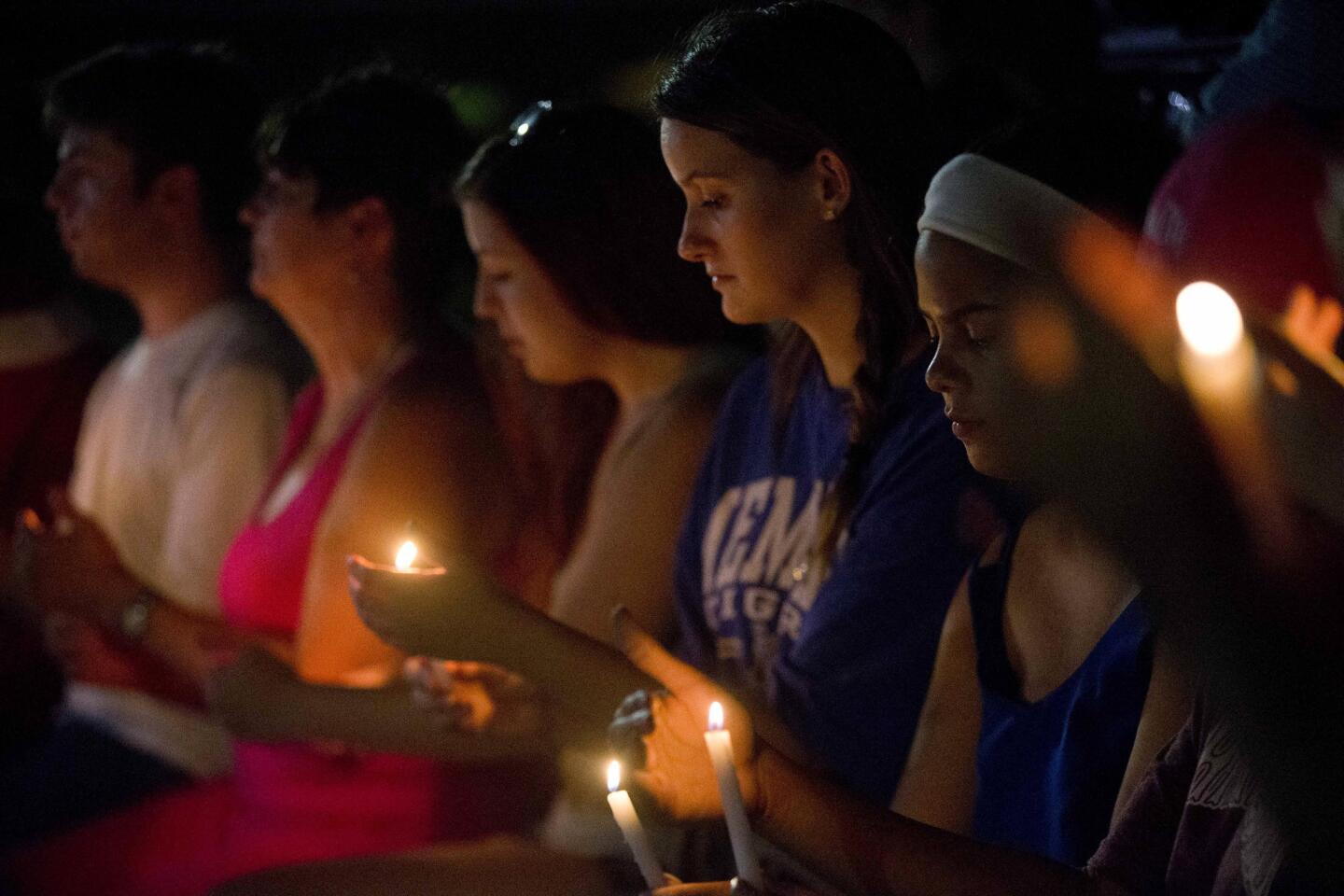 Mourners attend a vigil to honor the victims of Thursday night's shooting at The Grand 16 theater in Lafayette, La.