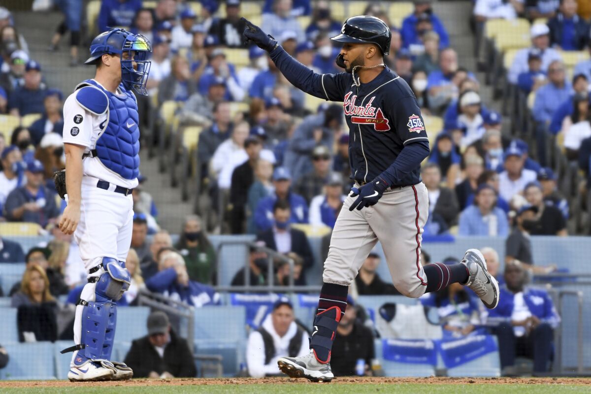 Atlanta's Eddie Rosario scores in front of Dodgers catcher Will Smith after hitting a solo home run.