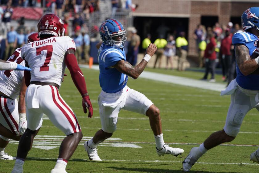 Mississippi quarterback Matt Corral (2) attempts to run up field as Arkansas defensive back Joe Foucha (7) closes in for a tackle during the first half of an NCAA college football game, Saturday, Oct. 9, 2021, in Oxford, Miss. Mississippi won 52-51. AP Photo/Rogelio V. Solis)