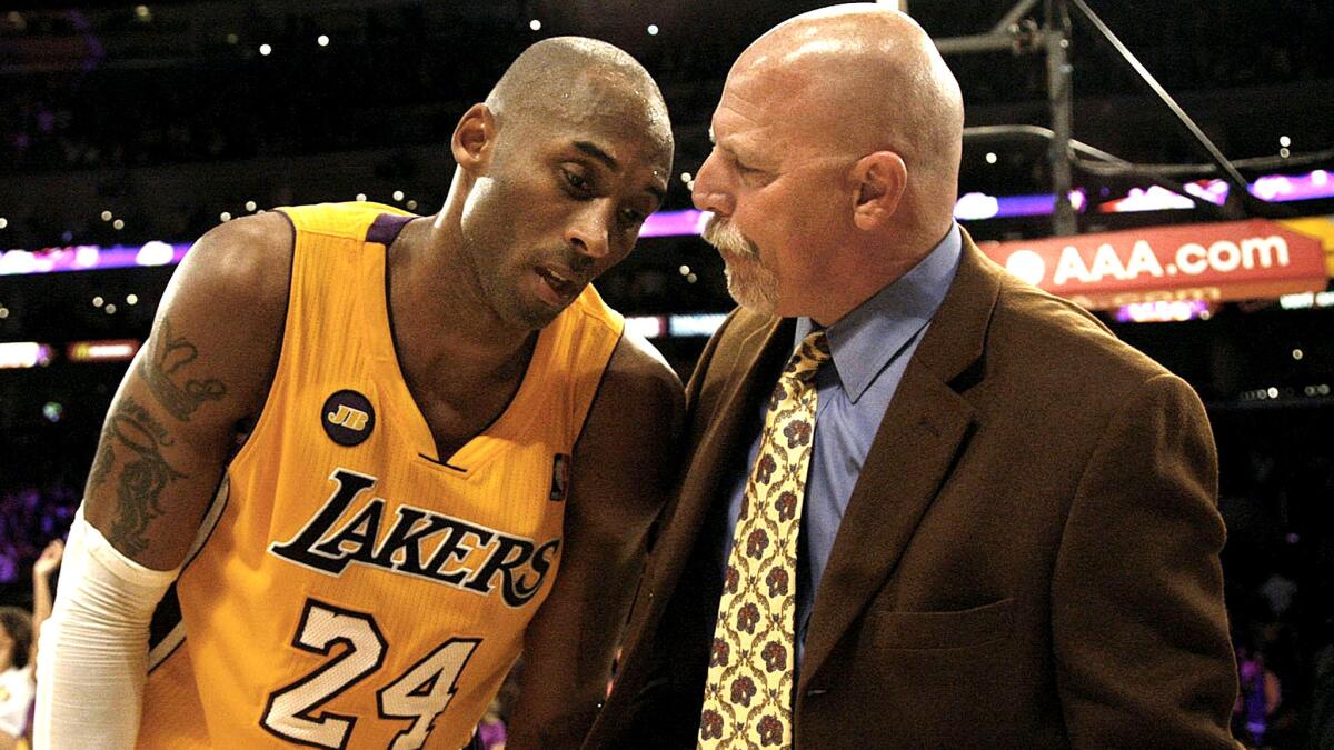 Trainer Gary Vitti talks to an exhausted Kobe Bryant.