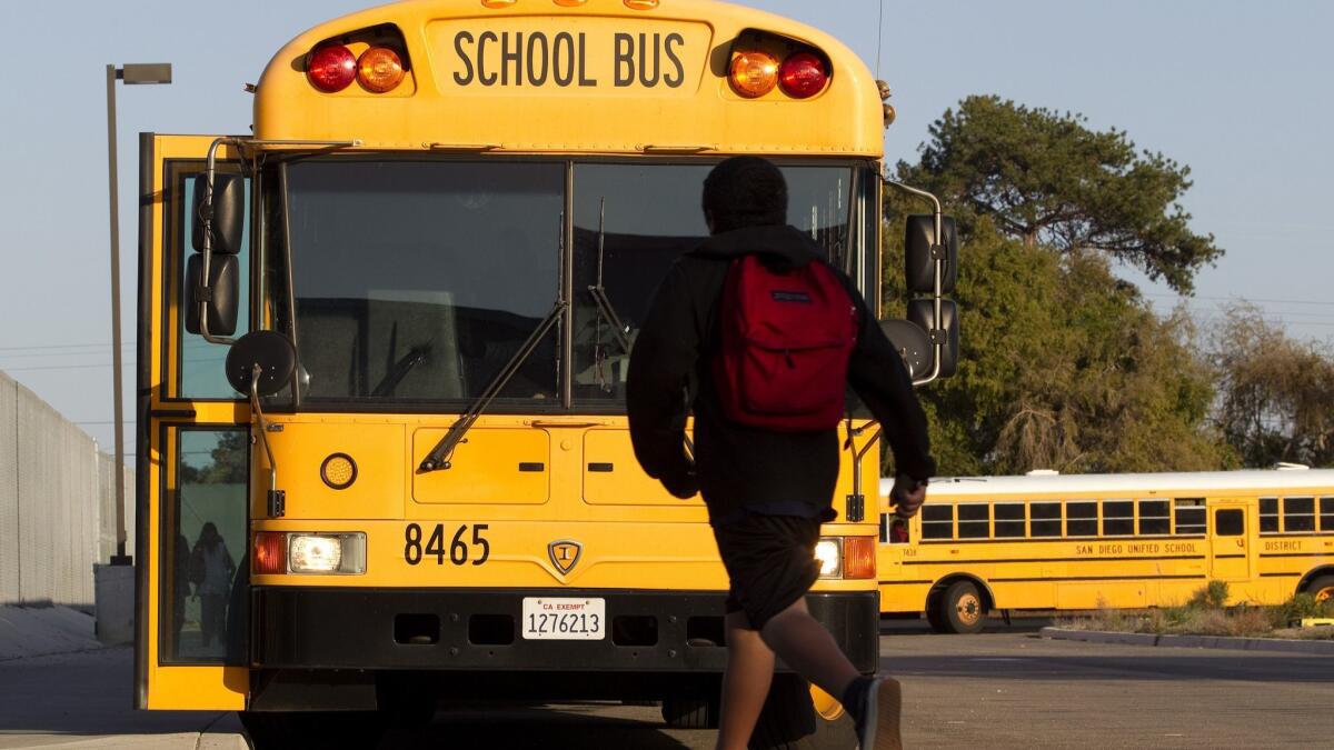 A student boards a bus at the Creative, Performing and Media Arts Magnet Middle School in Clairemont Mesa. (John R. McCutchen/UT San Diego)