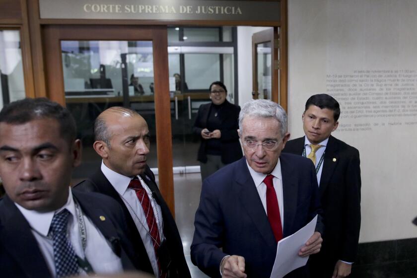 FILE - In this Oct. 8, 2019 file photo, senator and former president Alvaro Uribe arrives to the Supreme Court for questioning in an investigation for witness tampering charges in Bogota, Colombia. Uribe will not be allowed to remain at liberty while the Supreme Court investigates the allegations against him, current President Ivan Duque said in a video address Tuesday, Aug. 4, 2020. (AP Photo/Ivan Valencia, File)