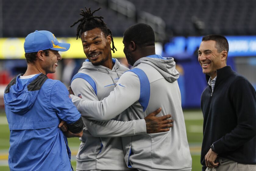 Inglewood, CA, Thursday, December 16, 2021 - Chargers safety Derwin James hugs Lucius Jordan, assistant strength coach, as coach Brandon Staley and general manager Tom Telesco look on hours before taking on the Kansas City Chiefs at SoFi Stadium. James is recovering from a hamstring injury and was a game time decision. He had just worked out and received the go ahead to play,. (Robert Gauthier/Los Angeles Times)