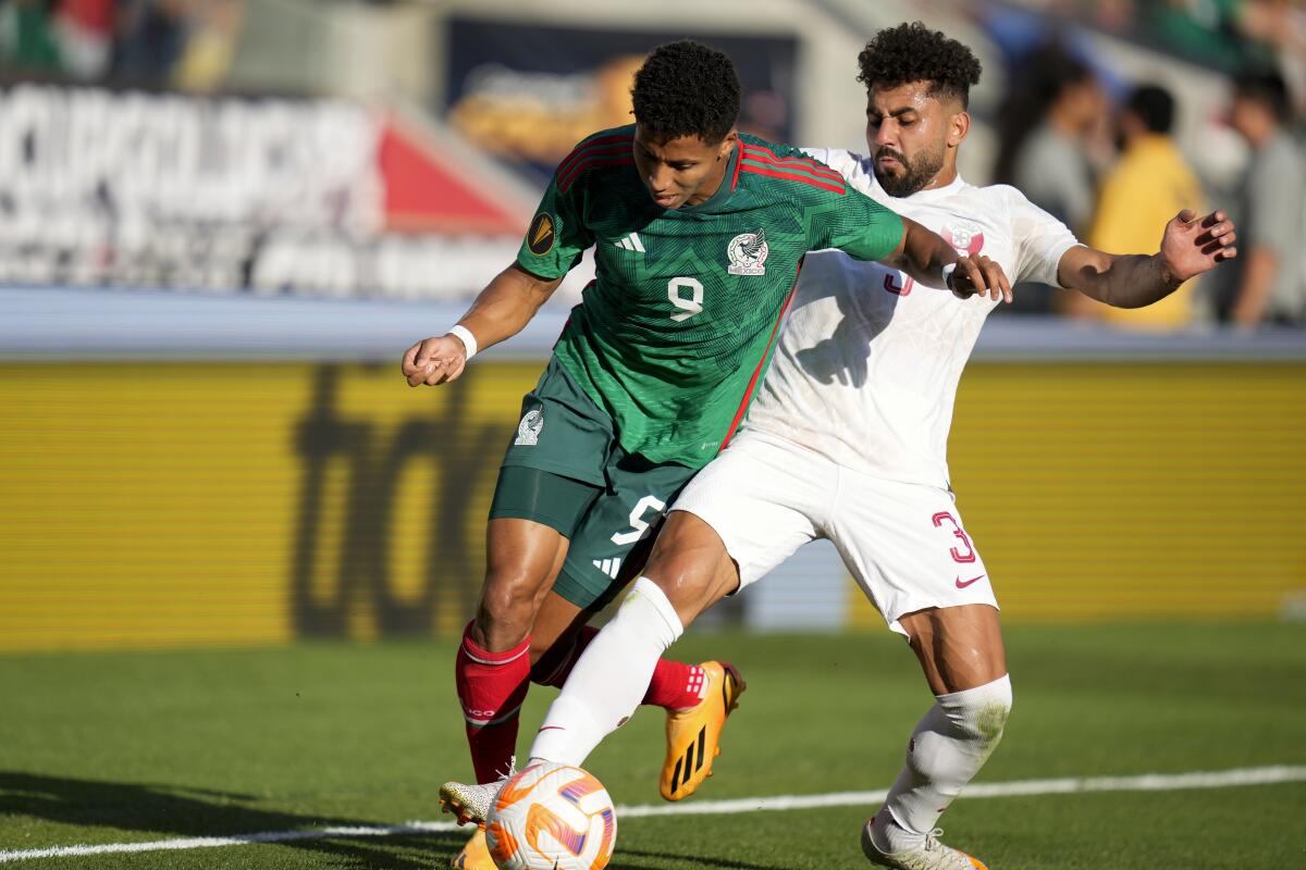 Mexico forward Ozziel Herrera is fouled by Qatar defender Hazem Shehata.
