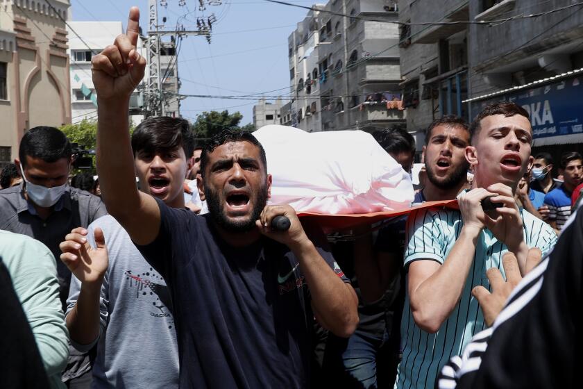 Mourners chant Islamic slogans while they carry the body of Amira Soboh, and her 19-year-old disabled son Abdelrahman, who were killed in Israeli airstrikes at their apartment building, during their funeral at the Shati refugee camp, in Gaza City, Tuesday, May 11, 2021. (AP Photo/Adel Hana)