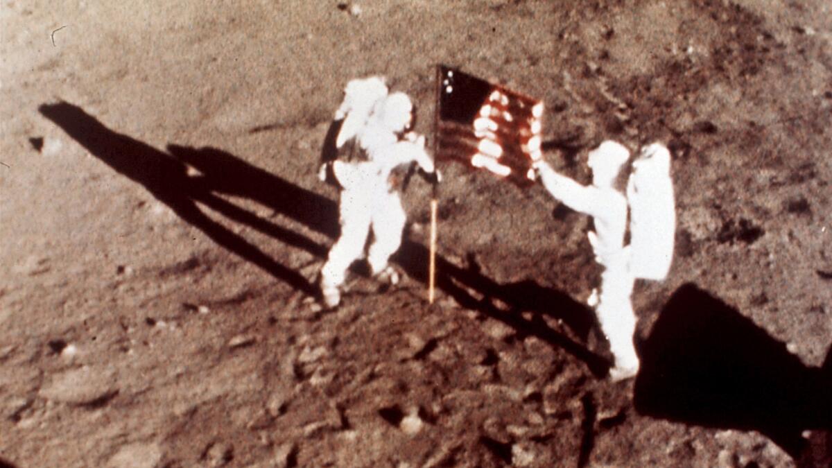 Apollo 11 astronauts Neil Armstrong and Buzz Aldrin plant the U.S. flag on the lunar surface. A new study finds astronauts who traveled to the moon are more likely to die of cardiovascular disease than those who stayed in low-Earth orbit.