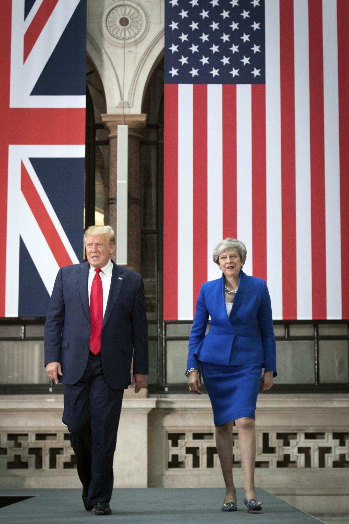 British Prime Minister Theresa May and President Trump arrive for a news conference in London on Tuesday.