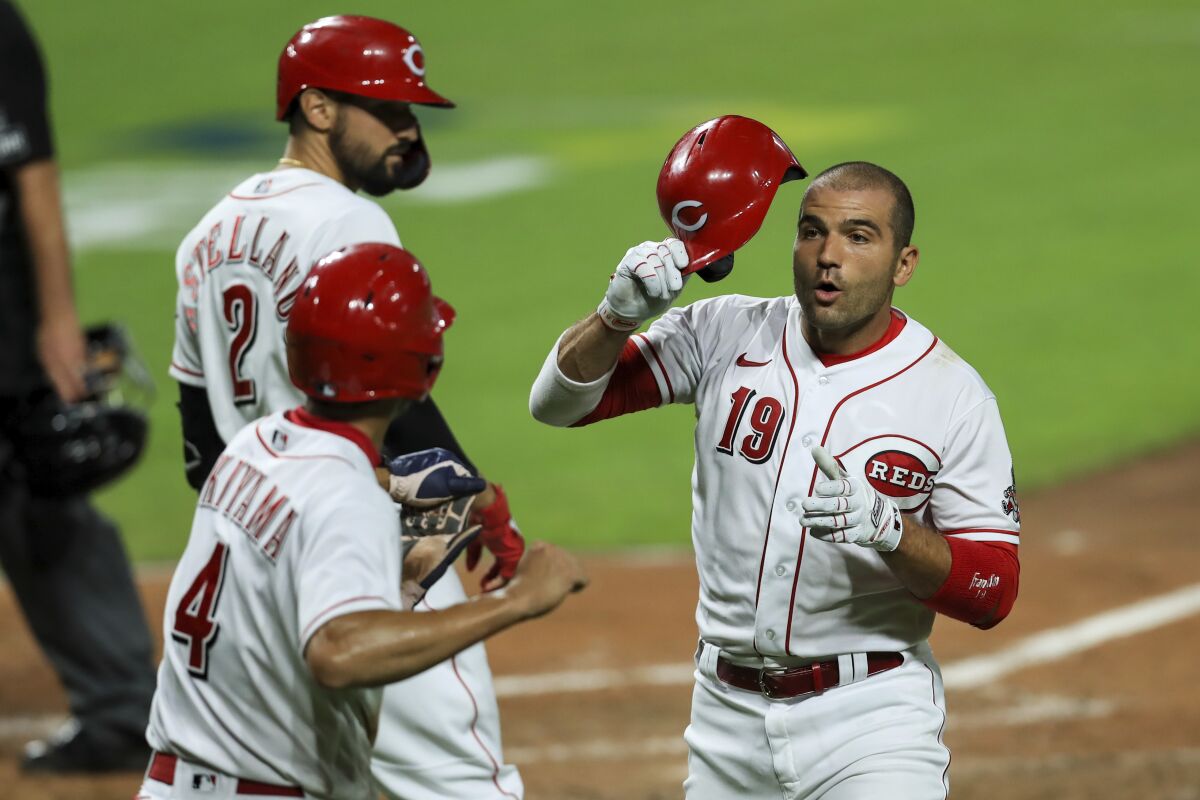 Cincinnati Reds' Joey Votto (19) is congratulated by teammates after hitting a two-run home run in the sixth inning of the team's baseball game against the Cleveland Indians in Cincinnati, Monday, Aug. 3, 2020. (AP Photo/Aaron Doster)