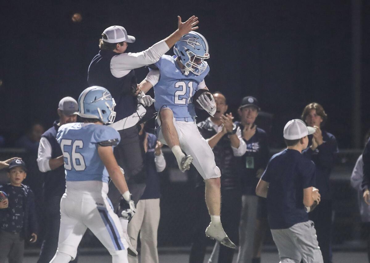 Corona del Mar's Brady Gadol (21) leaps into the air after intercepting a pass to seal the victory against Yorba Linda.
