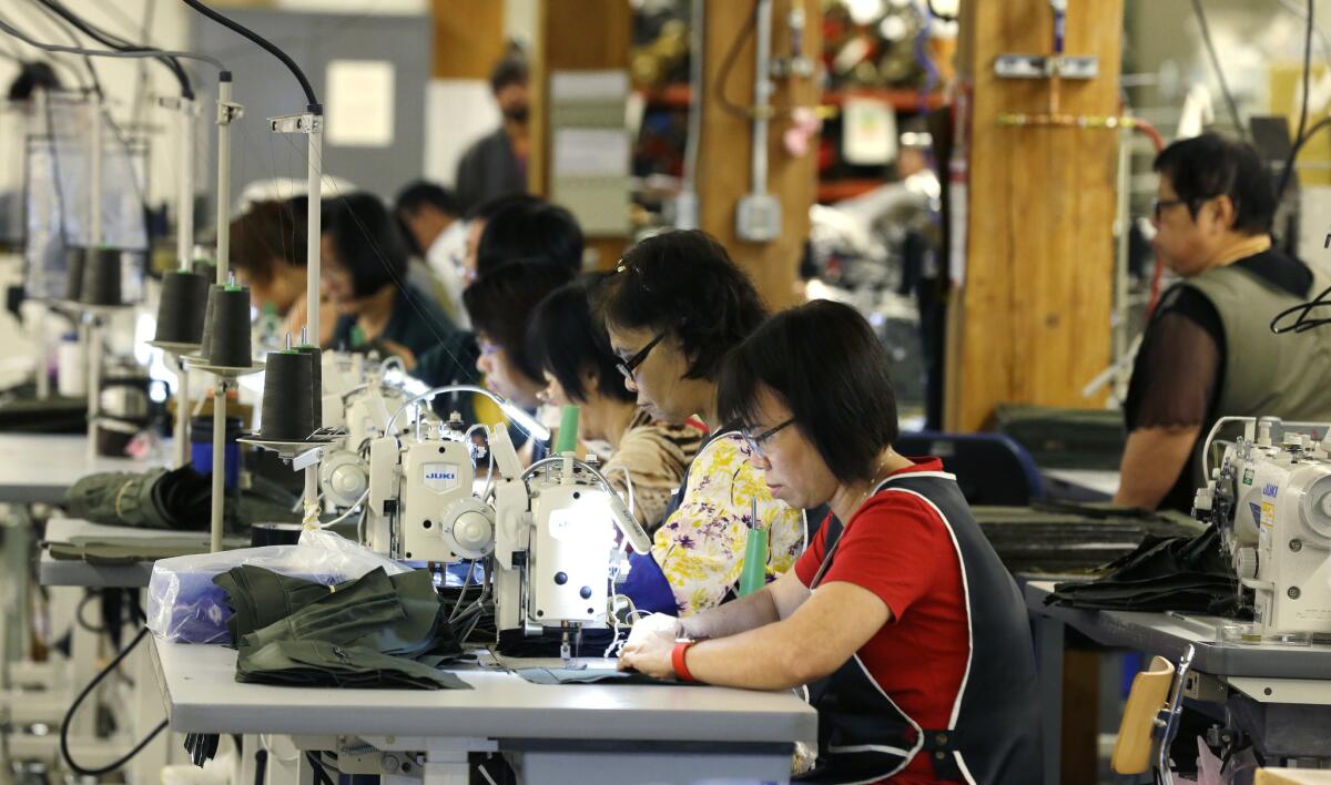 A group of workers at C.C. Filson Co. work at their sewing machines in Seattle on Aug. 31.