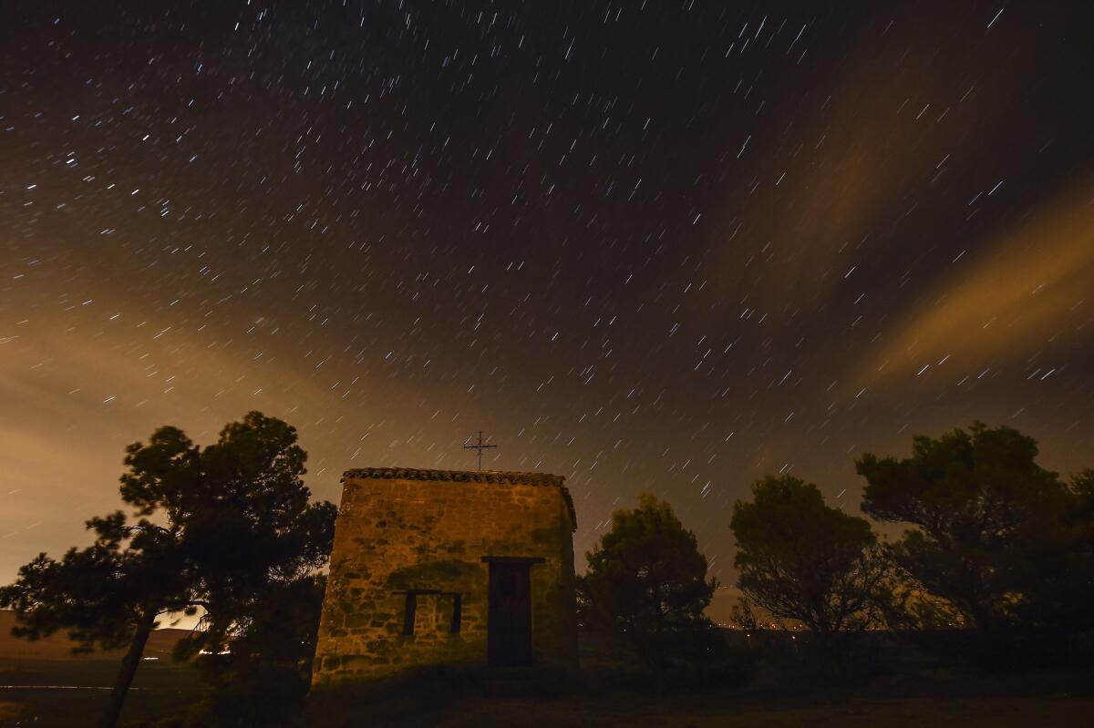 Stars seen as streaks from a long camera exposure are seen behind Arnotegui Hermitage, in Obanos, northern Spain, Tuesday, Aug. 11, 2015. Some Catholics refer to the Perseids as the "tears of Saint Lawrence", since 10 August is the date of that saint's martyrdom. (AP Photo/Alvaro Barrientos)