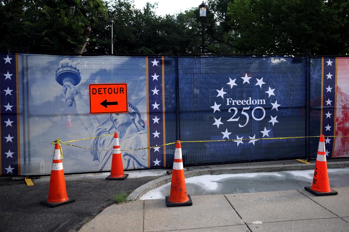 A "detour" sign appears on an image of the Statue of Liberty on screen fencing.