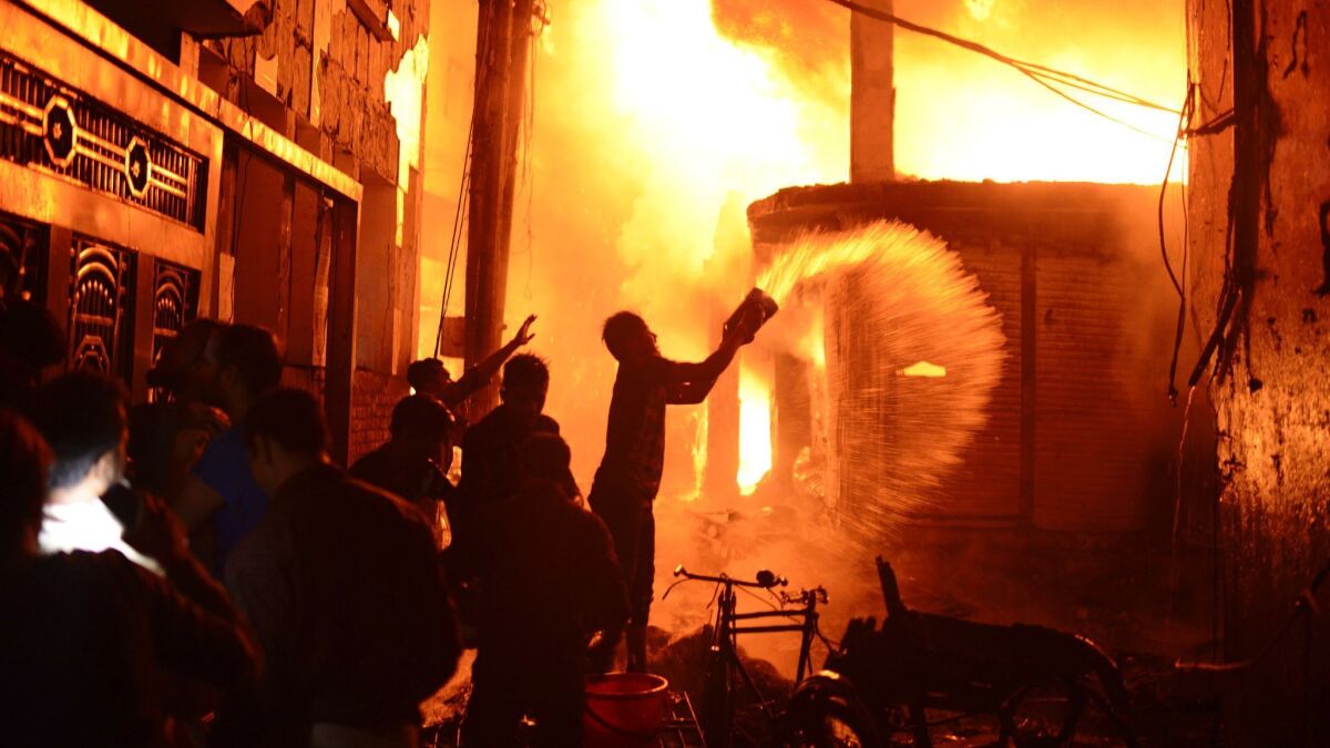 Firefighters and local people help douse a fire in the Chawkbazar district of Dhaka, Bangladesh, on Feb. 20.