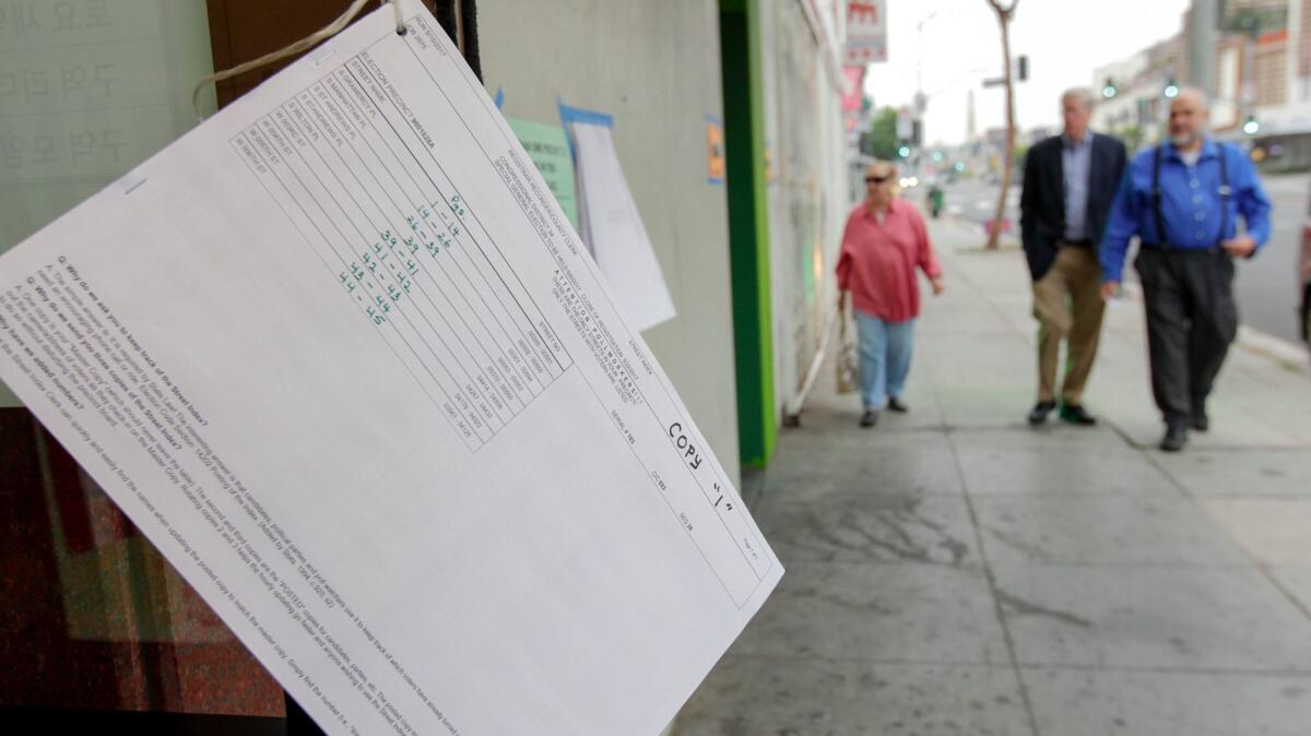 A list of registered voters hangs outside the polling place at an L.A. church for the 34th Congressional District special election.