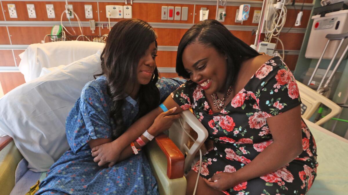 Tiara Parker, right, and Patience Carter, both wounded in the Pulse nightclub shooting, share a moment in the hospital.