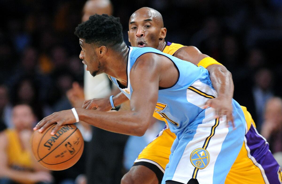 Kobe Bryant tries to steal the ball from Nuggets guard Emmanuel Mudiay at Staples Center on Nov. 3.
