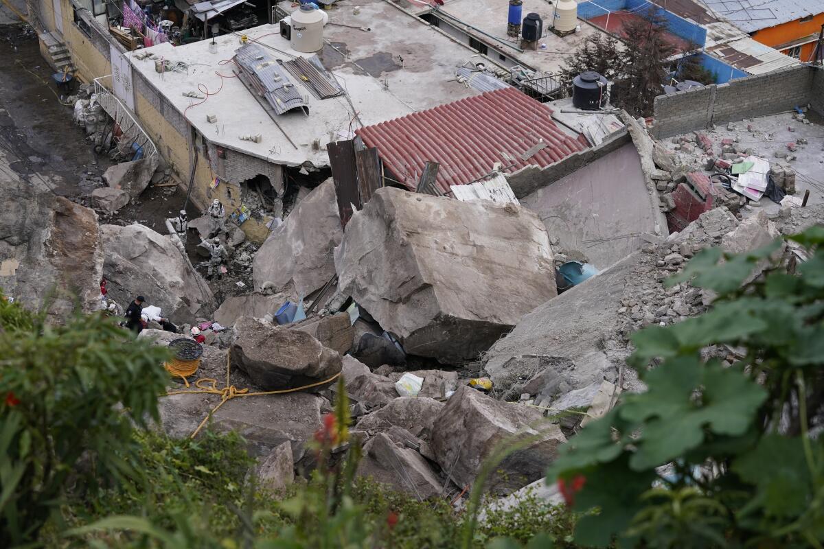 Boulders that plunged from a mountainside rests among homes in Tlalnepantla, on the outskirts of Mexico City, when a mountain gave way on Friday, Sept. 10, 2021. A section of mountain on the outskirts of Mexico City gave way Friday, plunging rocks the size of small homes onto a densely populated neighborhood and leaving at least one person dead and 10 others missing. (AP Photo/Eduardo Verdugo)