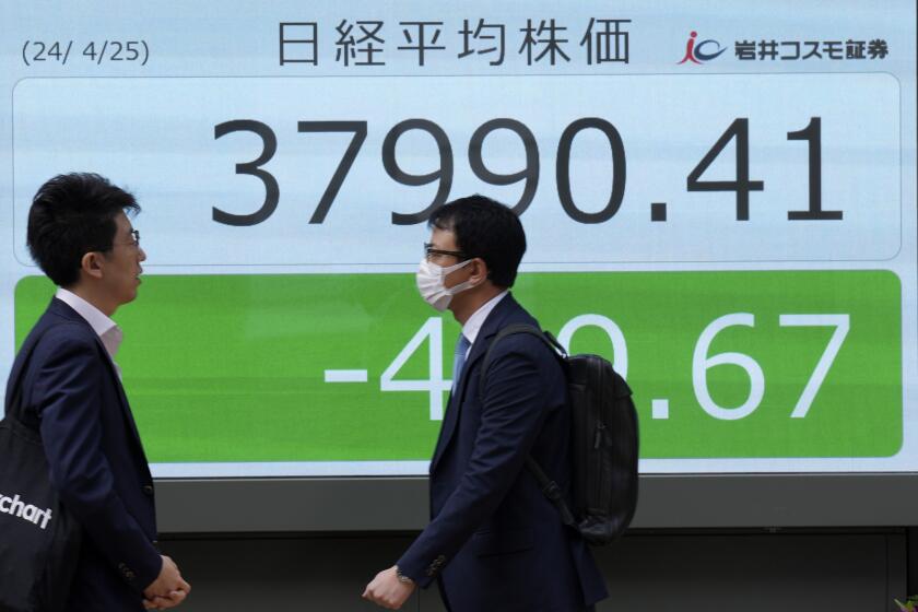 People walk in front of an electronic stock board showing Japan's Nikkei 225 index at a securities firm Thursday, April 25, 2024, in Tokyo. (AP Photo/Eugene Hoshiko)