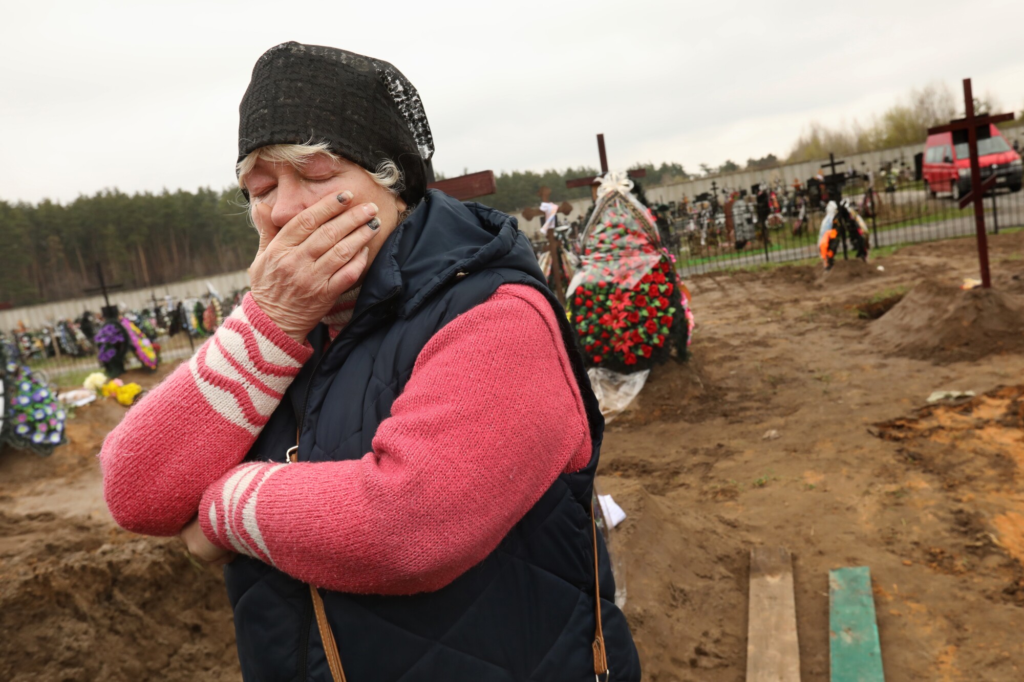 Woman grieves at a cemetery.