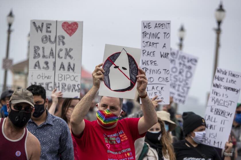 HUNTINGTON BEACH, CA - APRIL 11: Protesters gather for a Black Lives Matter rally on Sunday, April 11, 2021 in Huntington Beach, CA. (Brian van der Brug / Los Angeles Times)