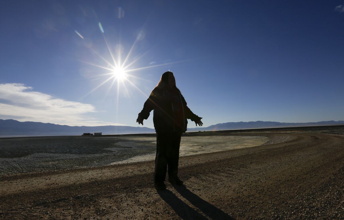 A woman stands in the middle of the dusty, saline Owens Lake.