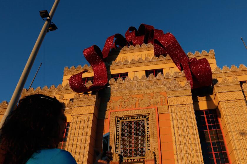Is it that time already? A visitor snaps a photo beneath the Citadel Outlets' Christmas bow.