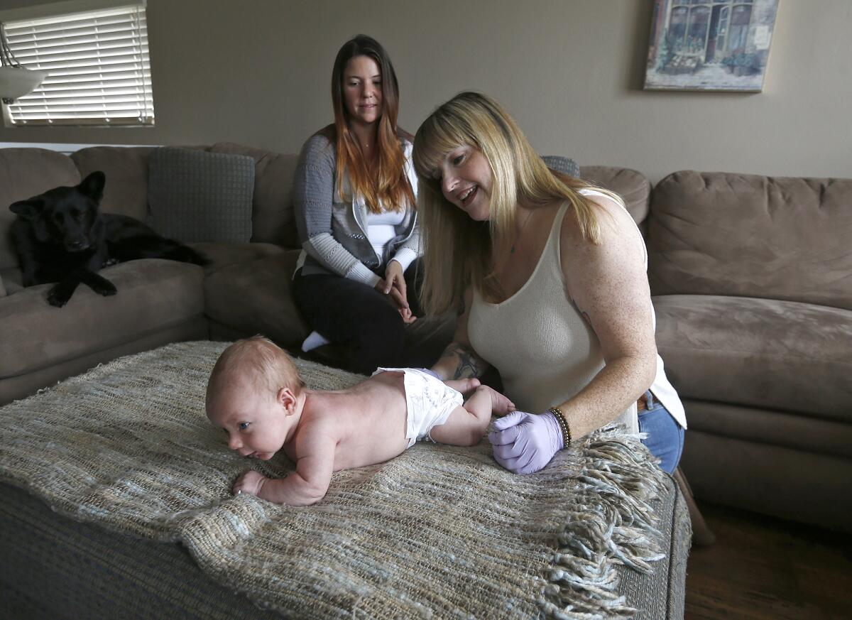Lactation consultant Rachelle King gives 6-week-old Bowen a mini-physical.