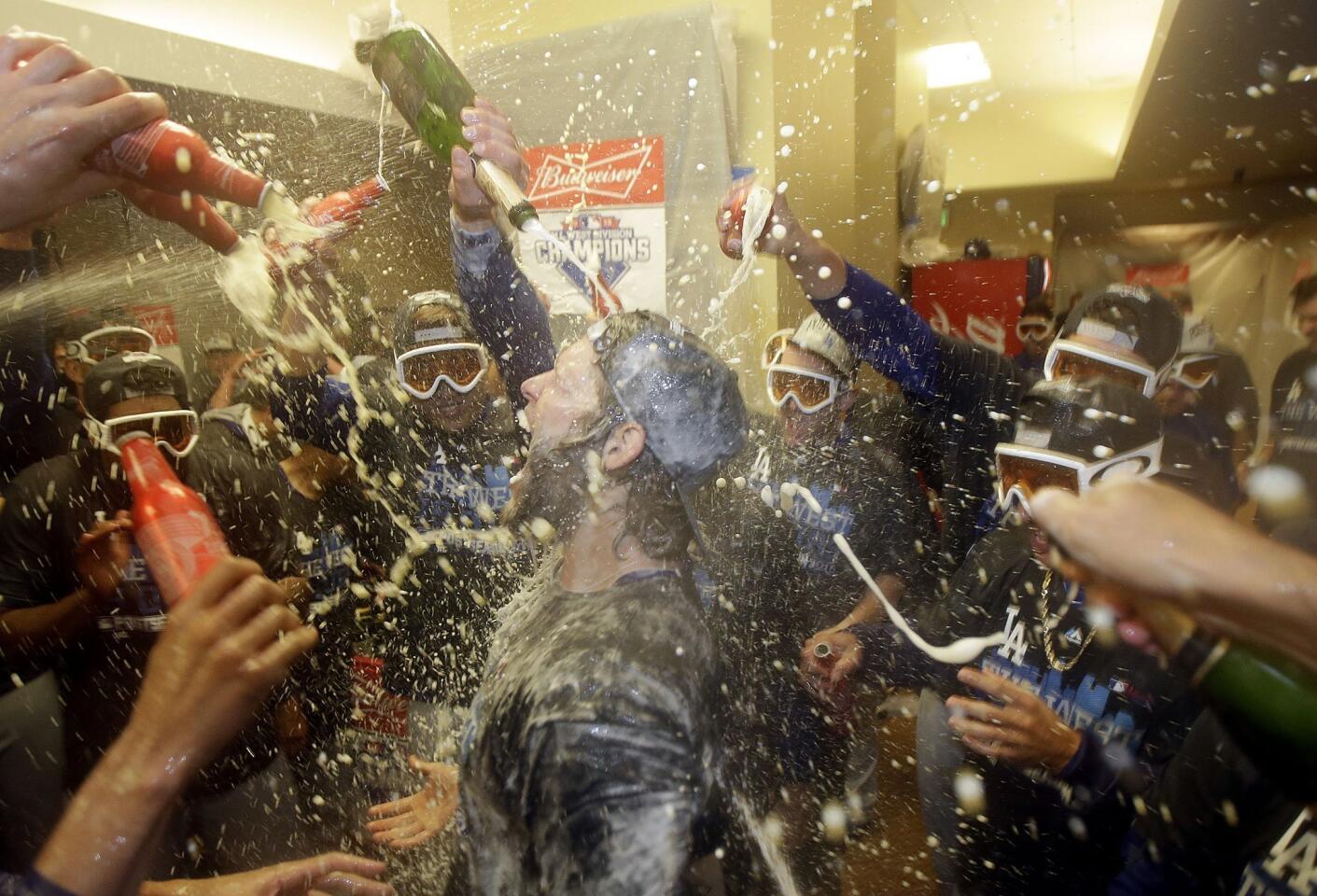 Los Angeles Dodgers pitcher Clayton Kershaw, center, celebrates with teammates in the locker room after the Dodgers beat the San Francisco Giants in a baseball game in San Francisco, Tuesday, Sept. 29, 2015. The Dodgers won 8-0 to clinch the National League West division. (AP Photo/Jeff Chiu)