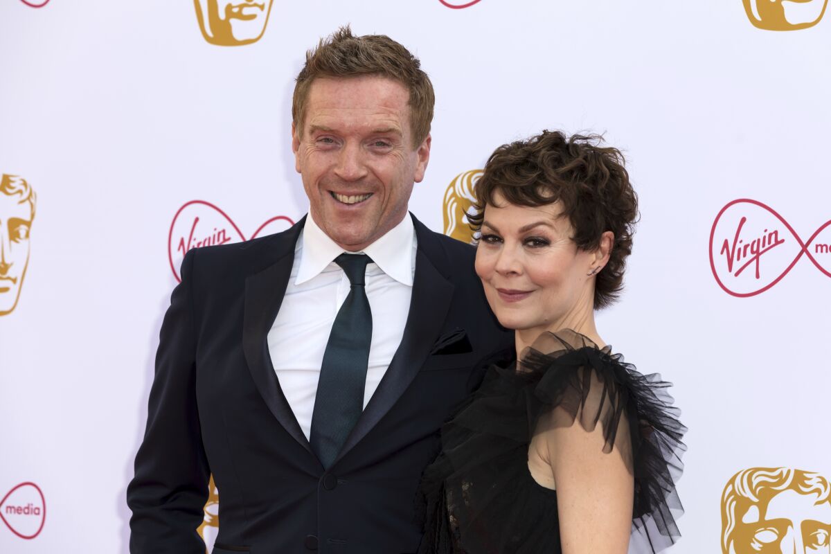 FILE - Actor Damian Lewis and partner actress Helen McRory pose for photographers on arrival at the 2019 BAFTA Television Awards in London, May 12, 2019. Lewis is among hundreds of Britons honored by Queen Elizabeth II on Wednesday as she celebrates 70 years on the throne. Lewis, 51, was recognized for services to drama and charity. He and his wife Helen McCrory raised money for a charity providing meals to health care workers during COVID-19 lockdowns. McCrory, an actor who starred in TV drama “Peaky Blinders,” died of cancer in 2021 aged 52. (Photo by Grant Pollard/Invision/AP, File)