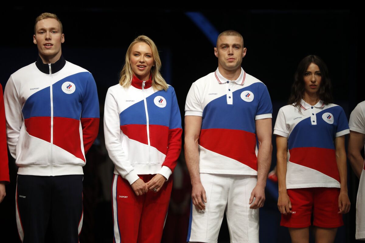 Athletes display the Olympic uniforms for Russian athletes in Moscow, Russia, Wednesday, April 14, 2021. Russia presents its Olympic kit for the Tokyo Games, which shouldn't depict any symbols of the country. Russian athletes will compete at the Tokyo Olympics as neutral after the Court of Arbitration for Sport last December banned Russia from using its name, flag and anthem at any world championships for the next two years because of state-backed doping. (AP Photo/Pavel Golovkin)
