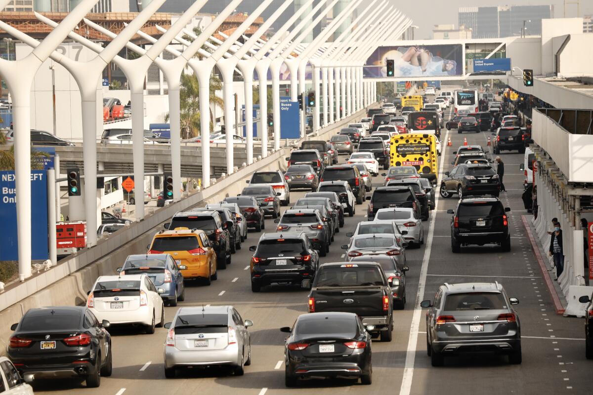 Lines of cars work there way around the horseshoe at Los Angeles International Airport on November 18, 2021. 