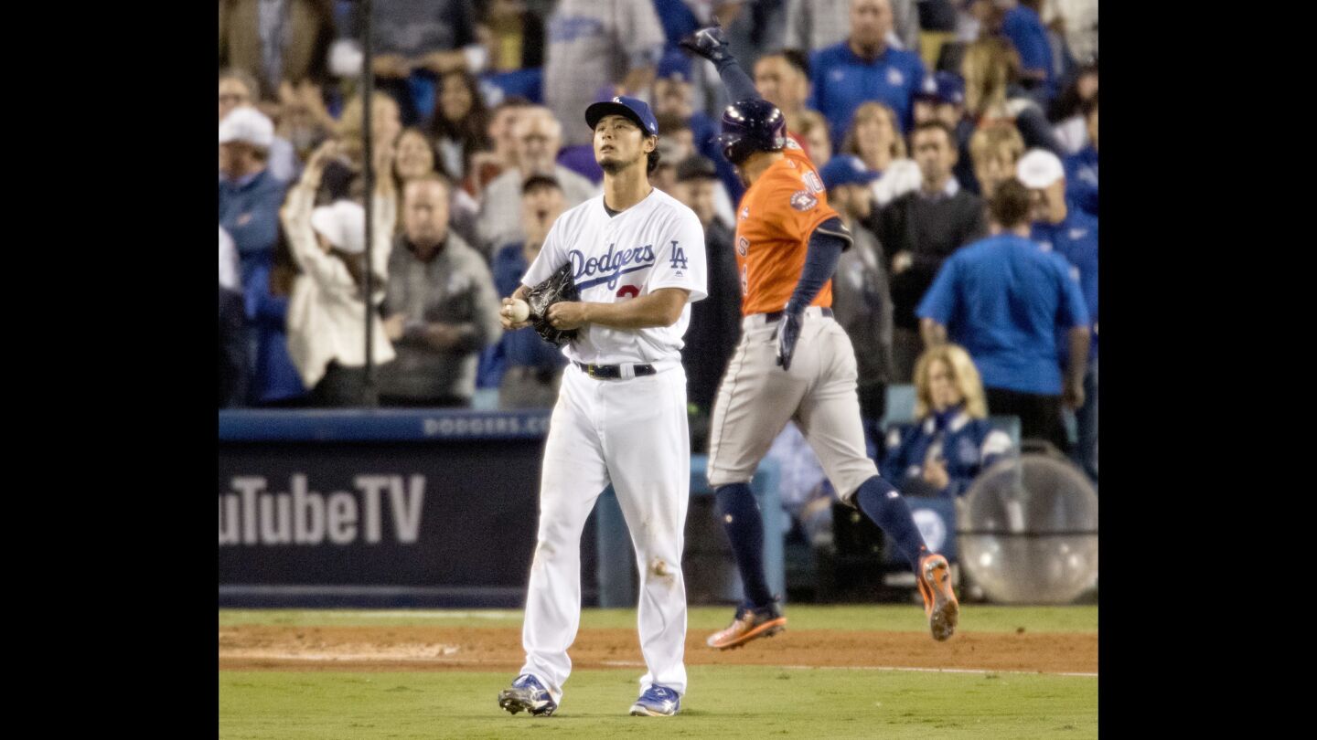 Dodgers starting pitcher Yu Darvish stares into the outfield as George Springer reaches home plate after hitting a 2-run homer to give the Astros a 5-0 lead in the second inning.