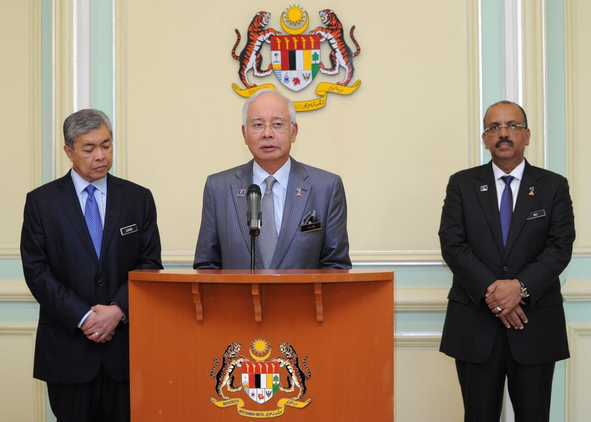 Malaysia's Prime Minister Najib Razak addresses a news conference in Putrajaya as newly appointed Deputy Prime Minister Ahmad Zahid Hamidi, left, and Malaysia's Chief Secretary Ali Hamsa listen.