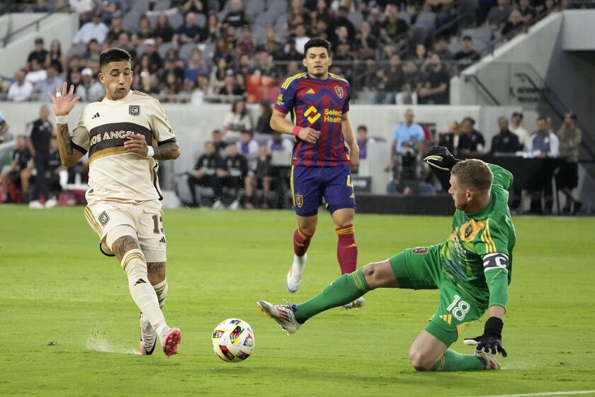 Los Angeles FC forward Cristian Olivera, left, gets the ball past Real Salt Lake goalkeeper Zac MacMath, right, before scoring on him during the first half of a MLS soccer match Wednesday, July 17, 2024, in Los Angeles. (AP Photo/Mark J. Terrill)